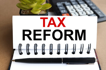 tax reform. text on white paper on the background of a calculator and plants.