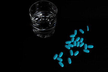 
Tablets with a glass of water and packaging
