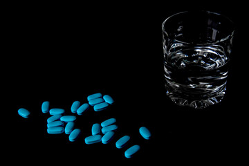 
Tablets with a glass of water and packaging