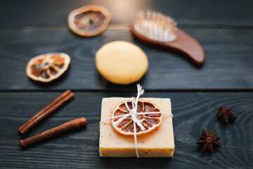 Natural handmade soap with dried slices of oranges and cinnamon on a dark background. Concept of Spa, body and skin care.  
