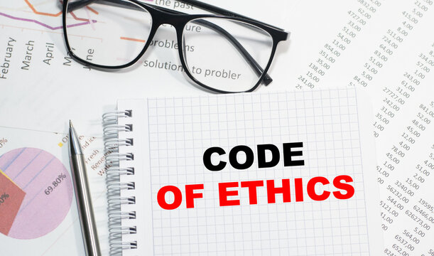 Business concept. Notebook with text CODE OF ETHICS sheet of white paper for notes, calculator, glasses, pencil, pen, in the white background