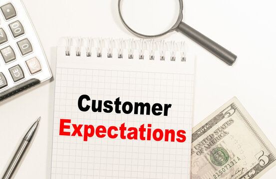 text Customer Expectations written on notepad with calculator, pensil, magnifier and dollars. Business concept