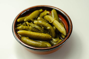 Small pickled cucumbers in brine according to a traditional recipe, served in a ceramic bowl