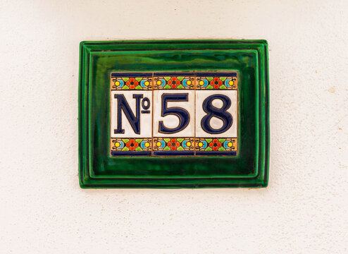Decorative ceramic house number 58 tile on the wall, characteristic decorative element