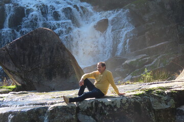 young man sitting on rocks