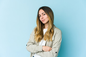 Young caucasian woman isolated on blue background unhappy looking in camera with sarcastic expression.