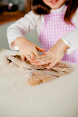 child's fingers knead the dough for gingerbread