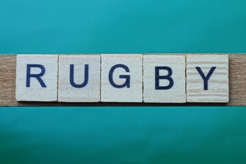 gray word rugby made of wooden square letters on green background