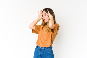 Young caucasian woman isolated on white background keeping eyes opened to find a success opportunity.