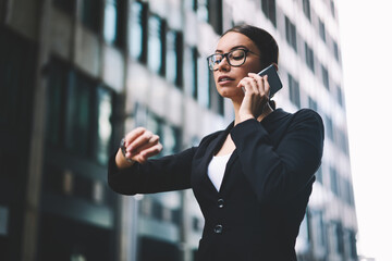 Manager talking on smartphone on street