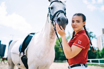 Horsewoman caressing grey stallions muzzle