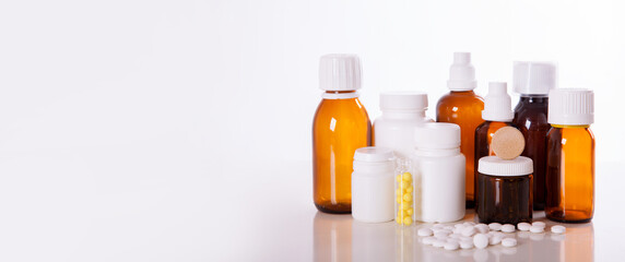 Medicinal pills and hot lemon tea, treatment of colds, flu and rhinitis. healthcare, traditional medicine and flu concept - cup of tea with lemon and pills. banner