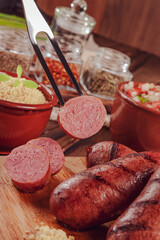 Grilled brazilian sausage on bbq fork with salad and farofa - Lingui&ccedil;a churrasco in close-up