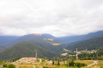 Fototapeta premium Magnificent panoramic view the coniferous forest on the mighty Mountains and beautiful blue sky background. Beauty of wild virgin Russian nature. Peacefulness.