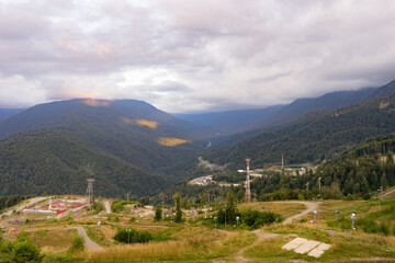 Magnificent panoramic view the coniferous forest on the mighty Mountains and beautiful blue sky background. Beauty of wild virgin Russian nature. Peacefulness.
