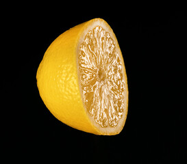 Sliced yellow lemon on the black background.