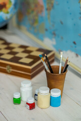 Brushes for drawing on a table with a globe. Schoolboy's Desk . Back to school. 