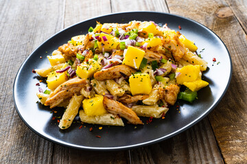 Chicken ragout with penne on wooden table