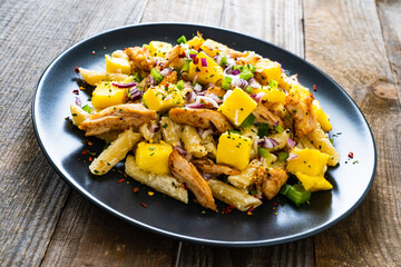 Chicken ragout with penne on wooden table