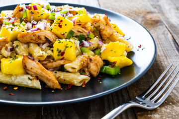Chicken ragout with penne on wooden table
