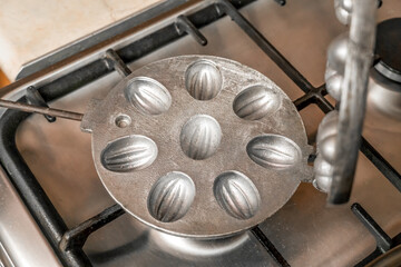 Empty round baking dish cookie Nut is heated on a gas stove, top view
