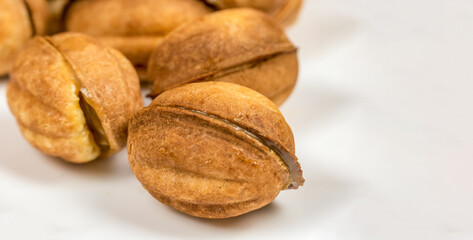 Lots of cookie Nut with boiled condensed milk on a white plate close-up with copy space, banner