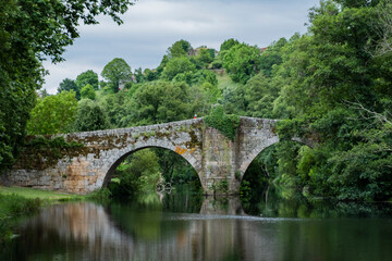 Fototapeta na wymiar Medieval bridge over Arnoia river in Allariz, Ourense. Galicia. Spain. Cloudy day.