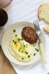 Cutlet, mashed potatoes with butter and parsley and tea on a wooden table.