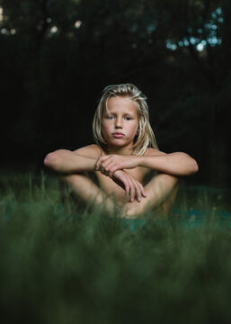 Portrait of a boy sitting in grass in the summer