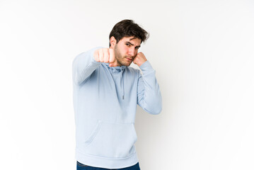 Young man isolated on white background throwing a punch, anger, fighting due to an argument, boxing.