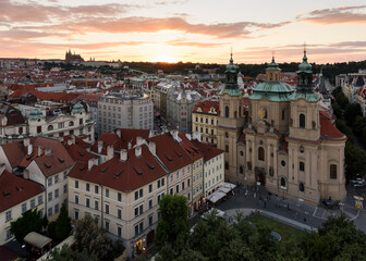 Naklejka na ściany i meble Beautiful evening aerial view of the sunset over the buildings and the historic center of Prague. Czech Republic.