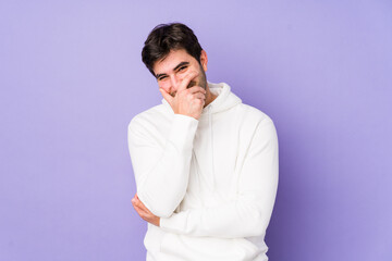 Young man isolated on purple background laughing happy, carefree, natural emotion.