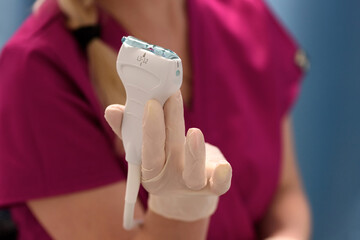 Medical ultrasound equipment in the clinic.
Close-up of a scanner covered with ultrasound gel in the doctor's hands. Health and beauty concept.