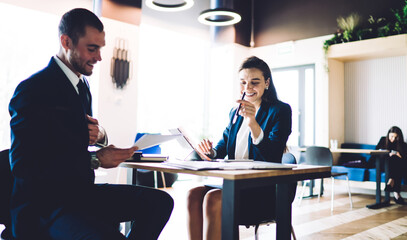 Businessman helping colleague with paperwork in office