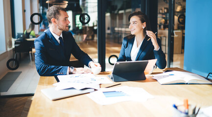 Two coworkers discussing business in office