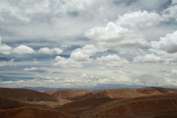 Desert landscape. Aerial view of the brown arid mountains and valley under a beautiful cloudy sky.