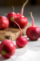 Fresh radish on a wooden board on a white background. View from above.