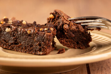 a slice of brownie on a plate on wooden table