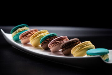 Sweet macaroons on a black background on wedding banquet