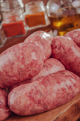 Raw brazilian sausages on the wooden board with ingredients - Linguiça churrasco close-up