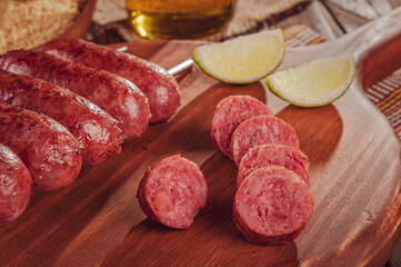 Slices grilled sausage on wooden board - Brazilian barbecue