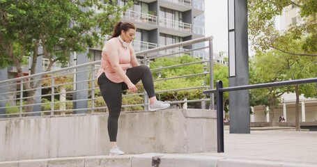 Young Caucasian woman tieing her shooes - Powered by Adobe