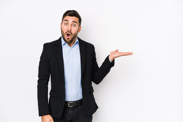 Young caucasian business man against a white background isolated impressed holding copy space on palm. - obrazy, fototapety, plakaty