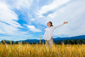 Girl holding arms up against blue sky
