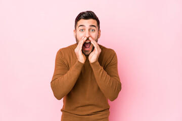 Young caucasian man against a pink background isolated shouting excited to front.
