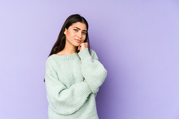Young indian woman isolated on purple background who feels sad and pensive, looking at copy space.