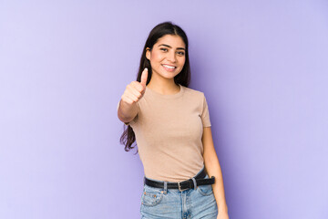 Young indian woman isolated on purple background smiling and raising thumb up