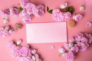 pink roses with white envelope and macaroons around pink background. life style concept