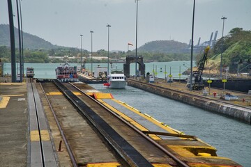 Naklejka premium Panoramic view of boat crossing Panama canal and the locks which regulate water in the canal