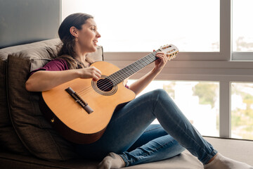 Happy woman playing guitar and singing